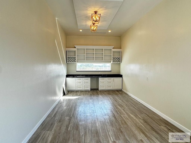 interior space featuring wood-type flooring and a tray ceiling