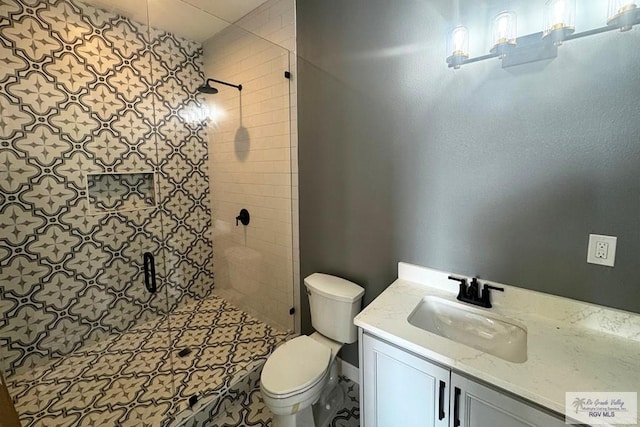 bathroom featuring vanity, toilet, and a shower with shower door