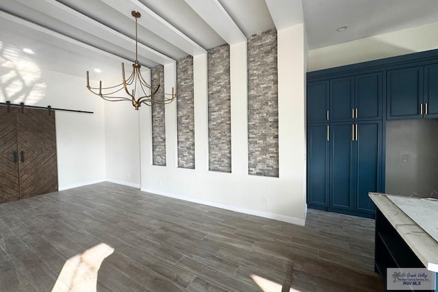 unfurnished dining area featuring a barn door and an inviting chandelier