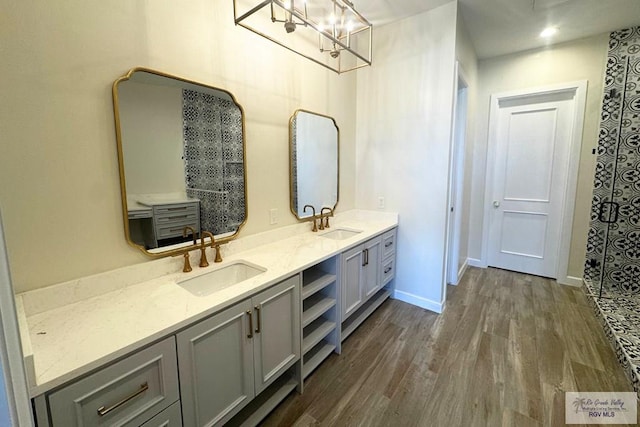 bathroom with hardwood / wood-style floors, vanity, and an inviting chandelier