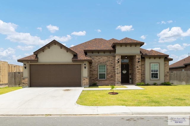 16620 W Duff Ct, Harlingen, TX 78552 - view of front of home featuring an attached garage, stucco siding, concrete driveway, and brick siding
