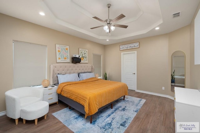 16620 W Duff Ct, Harlingen, TX 78552 - bedroom featuring a raised ceiling, wood finished floors, recessed lighting, ceiling fan, and arched walkways