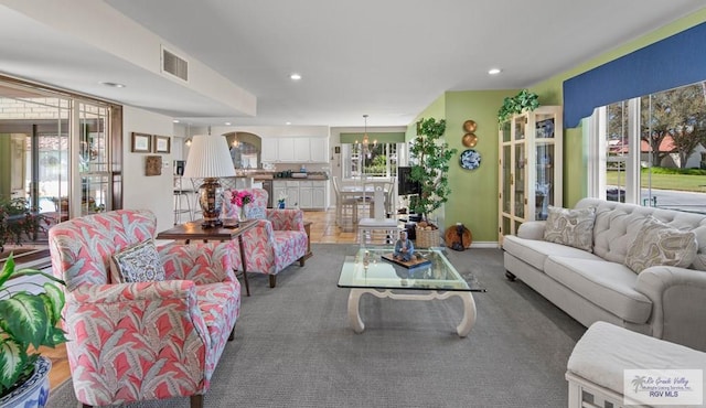 living room featuring recessed lighting, visible vents, baseboards, and an inviting chandelier