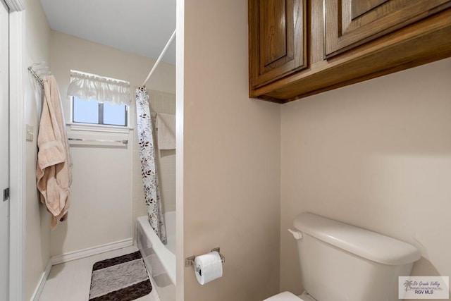 full bathroom with toilet, baseboards, and shower / bath combo