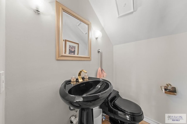 bathroom featuring lofted ceiling