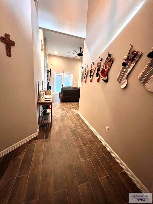 corridor with dark hardwood / wood-style floors, lofted ceiling, and french doors