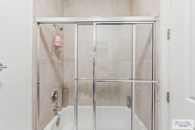 bathroom featuring bath / shower combo with glass door