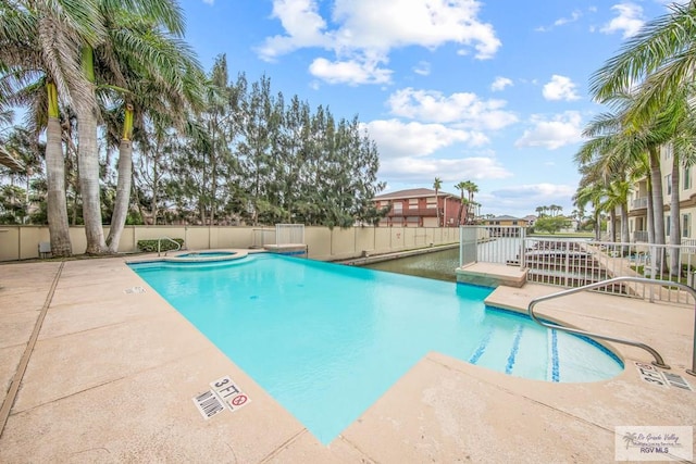 view of swimming pool with a patio and a hot tub