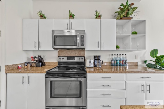 kitchen with white cabinetry, stainless steel appliances, and stone countertops