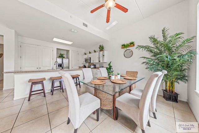 tiled dining area featuring ceiling fan and sink