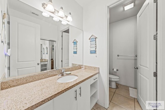 bathroom with tile patterned flooring, vanity, and toilet