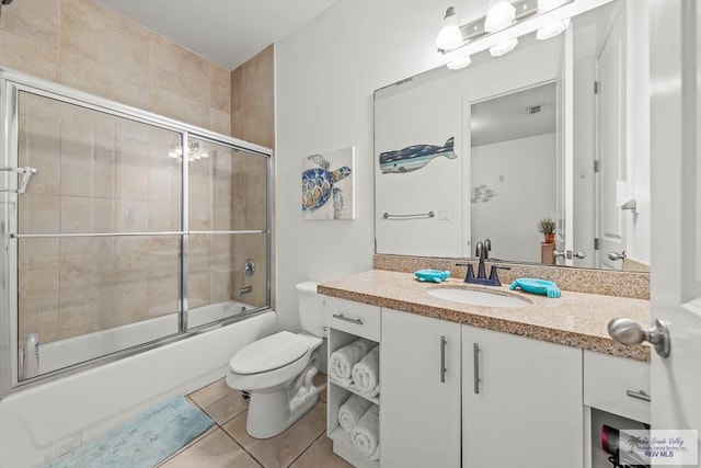 full bathroom with tile patterned floors, vanity, toilet, and combined bath / shower with glass door