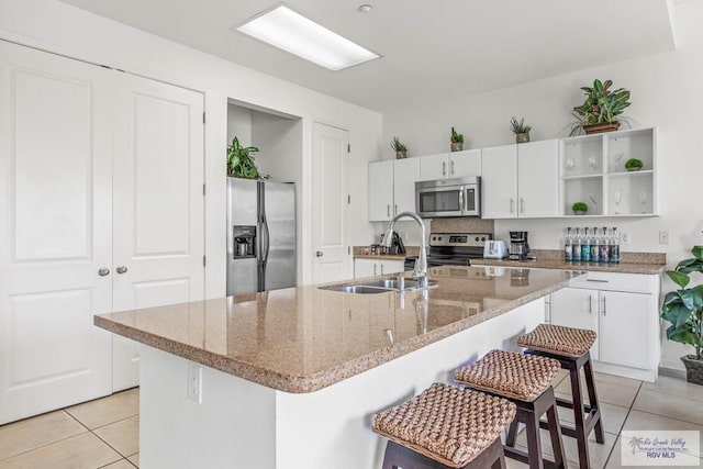 kitchen with white cabinets, a kitchen island with sink, sink, and appliances with stainless steel finishes