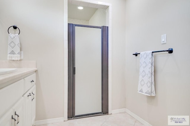 bathroom featuring tile patterned flooring, vanity, and walk in shower