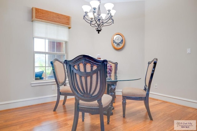 dining area with hardwood / wood-style flooring and a notable chandelier