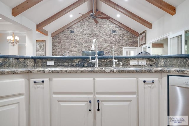 kitchen with white cabinets, dishwasher, ceiling fan with notable chandelier, and dark stone counters