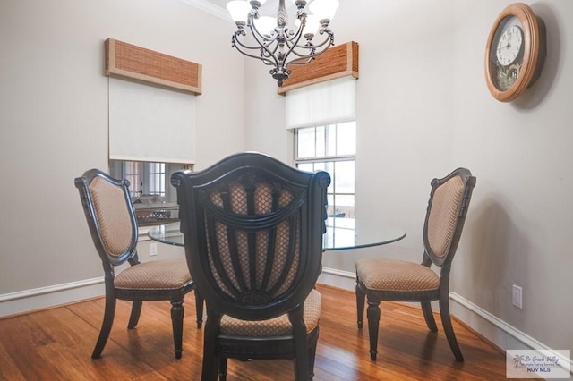 dining room with dark hardwood / wood-style flooring, an inviting chandelier, and crown molding