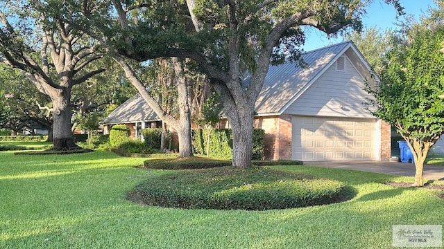 609 E Palm Valley Dr Unit 15, Harlingen, TX 78552 - view of front of property with brick siding, a front lawn, an attached garage, and a metal roof