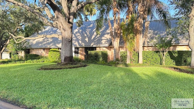 609 E Palm Valley Dr Unit 15, Harlingen, TX 78552 - view of front of home with a front yard and a metal roof