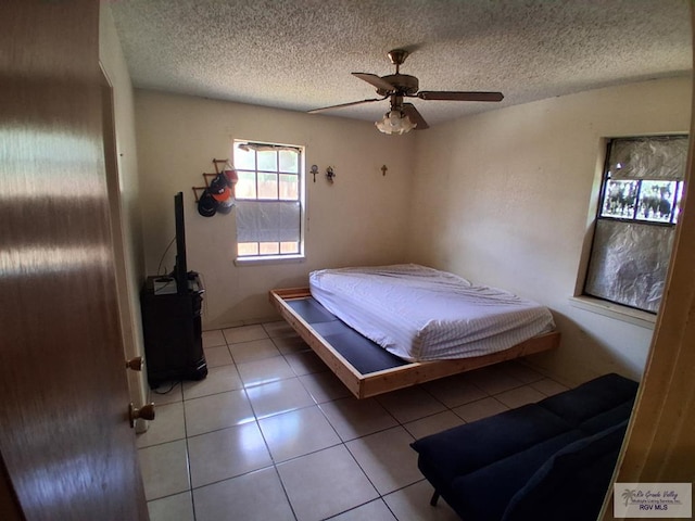 535 Windwood Way, Brownsville, TX 78526 - bedroom featuring light tile patterned floors, a textured ceiling, and ceiling fan