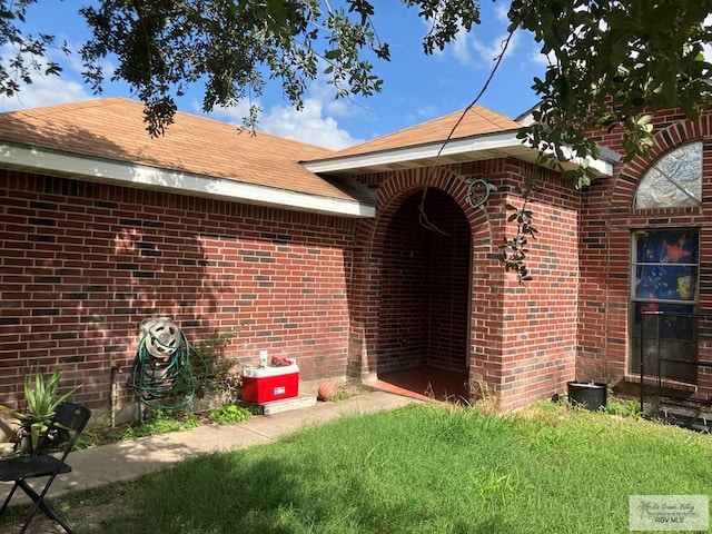 535 Windwood Way, Brownsville, TX 78526 - doorway to property with brick siding and roof with shingles