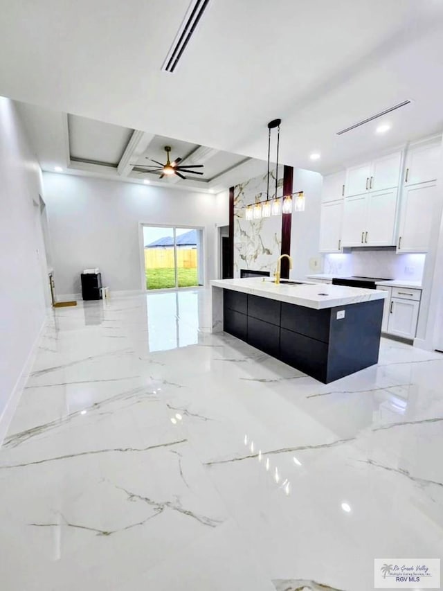 115 Finch Dr, Los Fresnos, TX 78566 - kitchen with light countertops, light marble finish flooring, decorative light fixtures, white cabinetry, and a spacious island