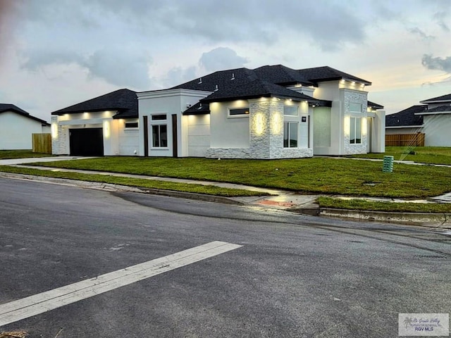 115 Finch Dr, Los Fresnos, TX 78566 - view of front facade featuring an attached garage, stone siding, stucco siding, and driveway