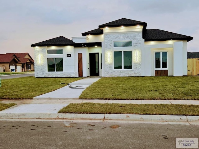 115 Finch Dr, Los Fresnos, TX 78566 - prairie-style house with stone siding, a front yard, and a shingled roof