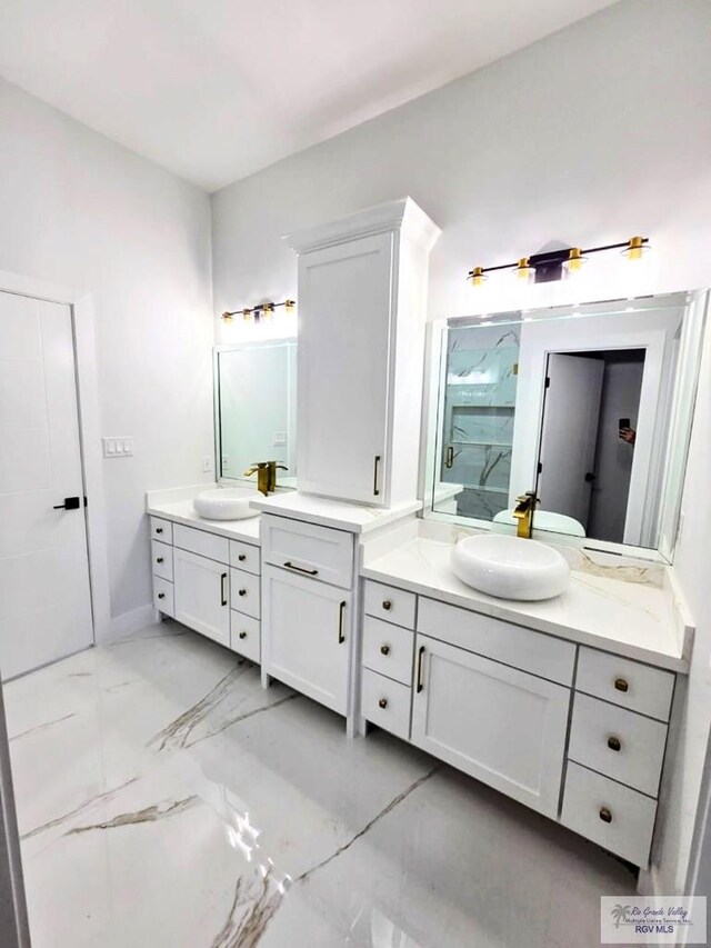 115 Finch Dr, Los Fresnos, TX 78566 - bathroom with two vanities, marble finish floors, and a marble finish shower