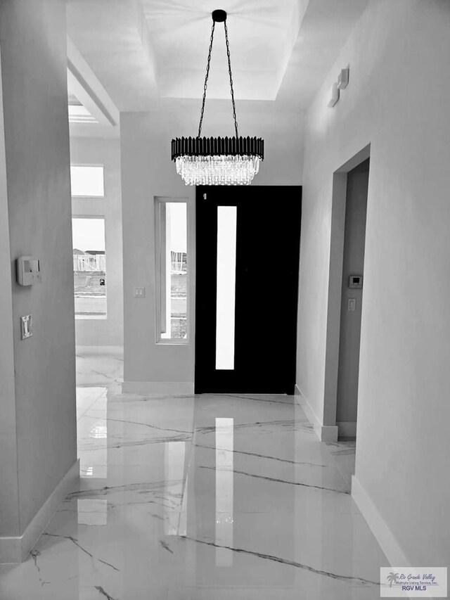 115 Finch Dr, Los Fresnos, TX 78566 - foyer entrance with a chandelier, marble tiled flooring, and a tray ceiling
