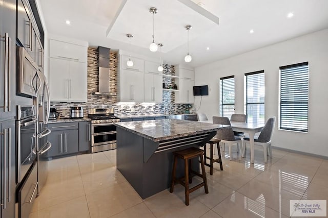 kitchen featuring stainless steel appliances, a kitchen island, white cabinets, hanging light fixtures, and open shelves