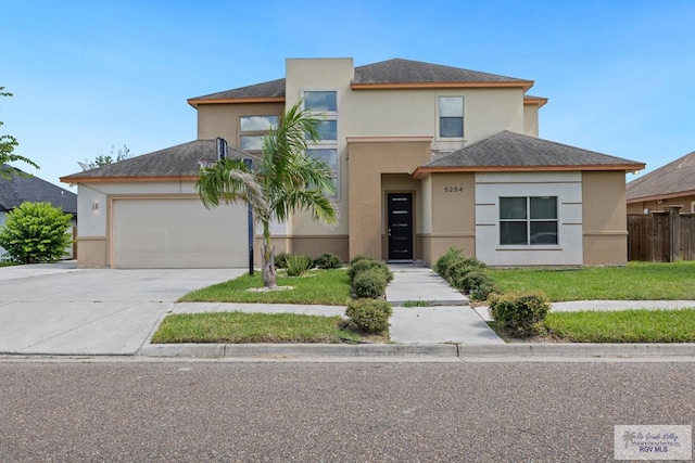 view of front of property with a garage, driveway, roof with shingles, stucco siding, and a front lawn