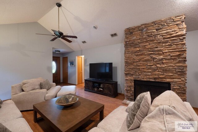1675 Chipinque Dr, Brownsville, TX 78526 - living area with ceiling fan, light wood-type flooring, vaulted ceiling, and a stone fireplace