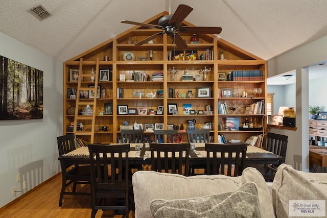 1675 Chipinque Dr, Brownsville, TX 78526 - dining space featuring lofted ceiling, ceiling fan, wood finished floors, and a textured ceiling
