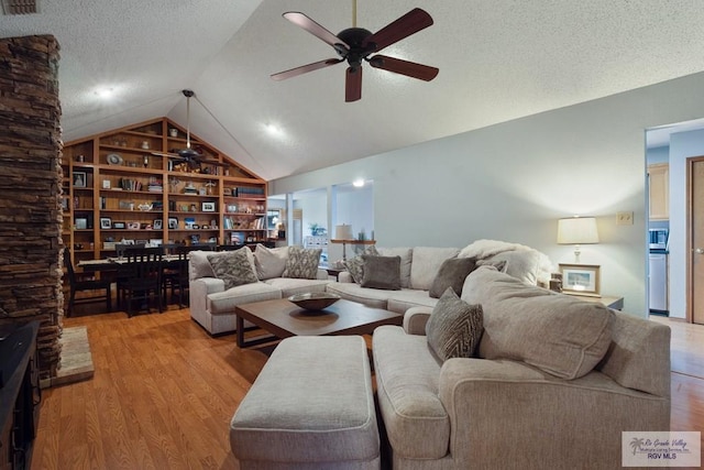 1675 Chipinque Dr, Brownsville, TX 78526 - living area with ceiling fan, vaulted ceiling, light wood-style flooring, and a textured ceiling