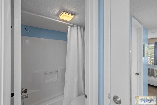 116 E Polaris Dr Unit 305, South Padre Island, TX 78597 - full bath featuring a textured ceiling, shower / bath combination with curtain, and ensuite bath