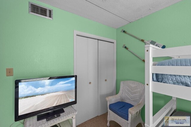 116 E Polaris Dr Unit 305, South Padre Island, TX 78597 - bedroom featuring a closet, carpet flooring, and a textured ceiling