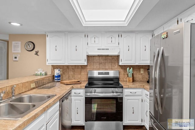 116 E Polaris Dr Unit 305, South Padre Island, TX 78597 - kitchen with appliances with stainless steel finishes, under cabinet range hood, white cabinetry, and recessed lighting