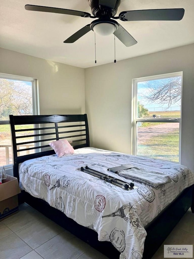 tiled bedroom with multiple windows and ceiling fan