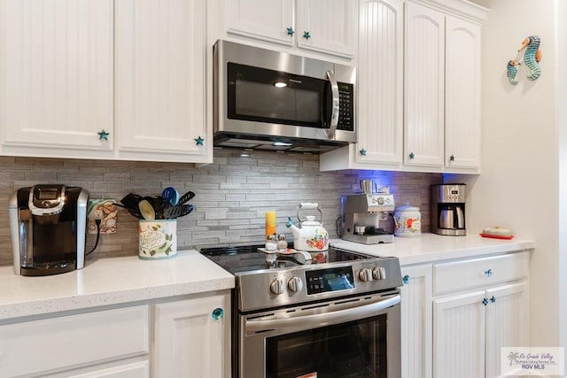 kitchen featuring decorative backsplash, white cabinets, light stone countertops, and appliances with stainless steel finishes