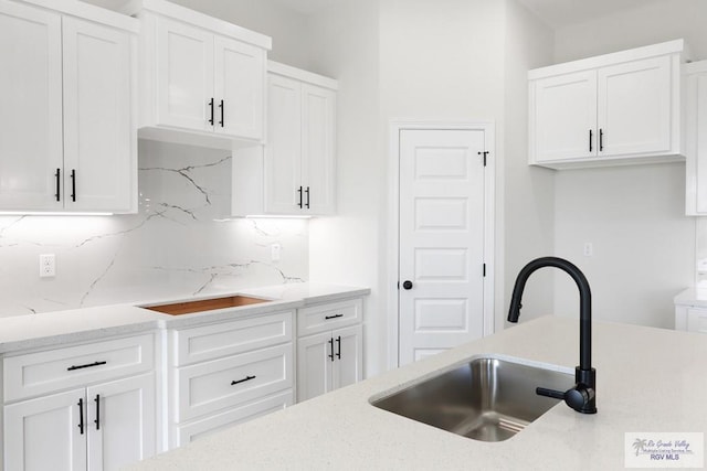 kitchen featuring tasteful backsplash and white cabinets