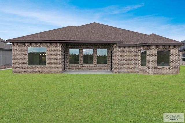 rear view of house featuring a yard and a patio