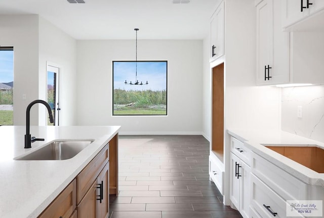 kitchen with pendant lighting, plenty of natural light, white cabinetry, and sink