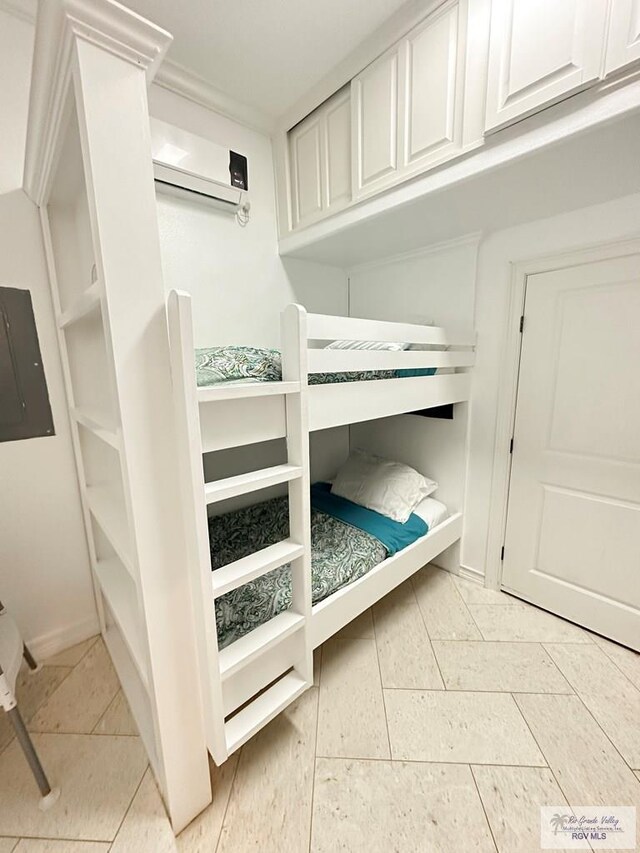 107 E Palm St Unit B, South Padre Island, TX 78597 - unfurnished bedroom featuring electric panel, a wall mounted air conditioner, and light tile patterned floors