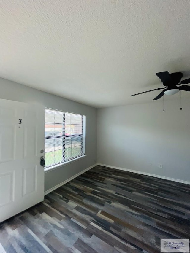 entrance foyer featuring a textured ceiling, ceiling fan, and dark wood-type flooring