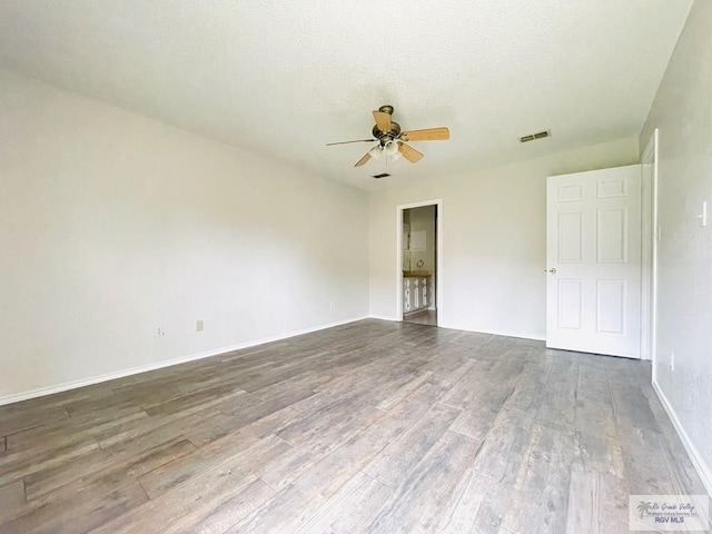 spare room with ceiling fan and wood-type flooring