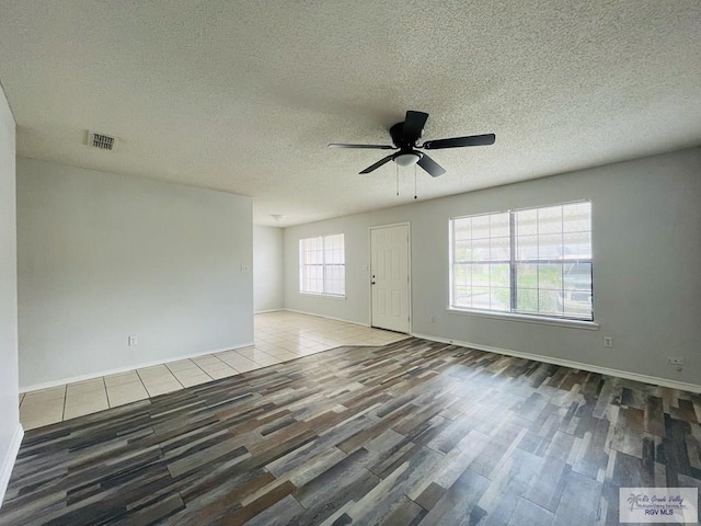 spare room featuring hardwood / wood-style floors, ceiling fan, and a textured ceiling