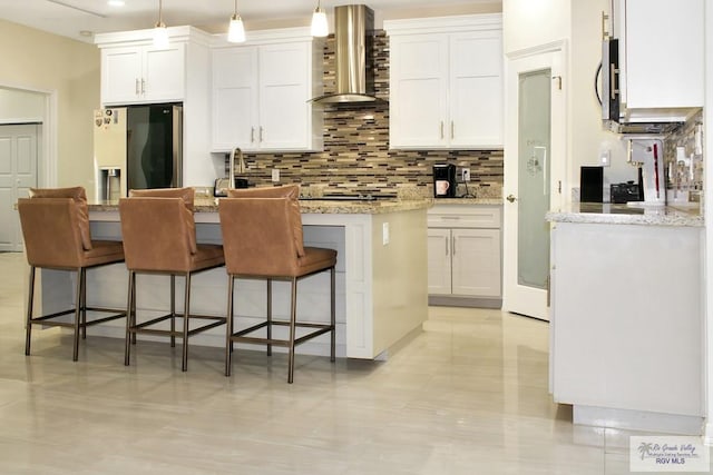 3512 Westcreek Dr, Brownsville, TX 78526 - kitchen featuring wall chimney exhaust hood, stainless steel appliances, decorative backsplash, and white cabinets