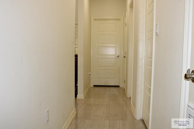 hallway featuring light tile patterned floors and baseboards