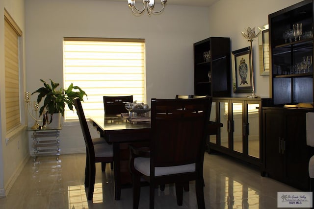 dining space featuring baseboards and a chandelier